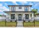 Charming two-story home features modern black and white color scheme, front yard landscaping and a black metal fence at 2328 W La Salle St, Tampa, FL 33607