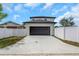 Rear exterior of the home with a dark garage door and concrete driveway at 2328 W La Salle St, Tampa, FL 33607