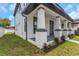 Side view of the exterior shows a columned porch with brick accents and fresh landscaping at the base of the columns at 2328 W La Salle St, Tampa, FL 33607