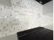 Close up of the designer white and gold marble backsplash tiles and stainless steel range in the kitchen at 2328 W La Salle St, Tampa, FL 33607
