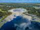 Aerial view showcasing a beautiful lake reflecting the sky and surrounded by trees at 2459 Parkstream Ave, Clearwater, FL 33759