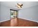 This bedroom features hardwood floors, a ceiling fan, and sliding glass doors to the pool area at 2459 Parkstream Ave, Clearwater, FL 33759