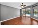 Bedroom with hardwood floors and sliding glass door leading to screened lanai and pool at 2459 Parkstream Ave, Clearwater, FL 33759