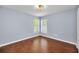 A bright bedroom with two windows and hardwood floors offers a simple and clean look at 2459 Parkstream Ave, Clearwater, FL 33759