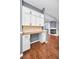 Kitchen nook area with wooden floors, a workspace, white cabinets, and a view of the fireplace at 2459 Parkstream Ave, Clearwater, FL 33759