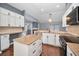Bright kitchen features white cabinetry, island, stone countertops, stainless steel appliances, and a view of the fireplace at 2459 Parkstream Ave, Clearwater, FL 33759