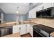 Bright kitchen with white cabinets, granite counters, and modern stainless steel appliances at 2459 Parkstream Ave, Clearwater, FL 33759