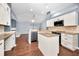 An open kitchen boasts granite countertops, stainless steel appliances, white cabinetry, and seamlessly connects to the living area at 2459 Parkstream Ave, Clearwater, FL 33759