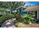 View of the home showing mature landscaping and walkway at 2459 Parkstream Ave, Clearwater, FL 33759