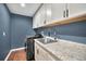 This laundry room features ample storage cabinets, granite countertops, and a modern washer and dryer at 2459 Parkstream Ave, Clearwater, FL 33759