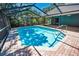 The screened-in pool area features a tile roof, a spacious layout, and lush landscaping for privacy at 2459 Parkstream Ave, Clearwater, FL 33759