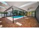 A covered pool area with skylights and brick flooring allows for year-round enjoyment and relaxation at 2459 Parkstream Ave, Clearwater, FL 33759