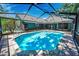 The screened-in pool features a spacious area with a beautiful tile roof and lush landscaping for privacy at 2459 Parkstream Ave, Clearwater, FL 33759