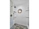 The stand-up shower features decorative tiles, pebble flooring, and a unique stained glass window at 2459 Parkstream Ave, Clearwater, FL 33759