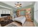 Well-lit bedroom featuring neutral walls, a built-in bookcase, a desk, and a ceiling fan at 2518 Dick Wilson Dr, Sarasota, FL 34240