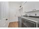 Functional laundry room with front-load washer, dryer and storage cabinets at 2518 Dick Wilson Dr, Sarasota, FL 34240