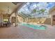 Beautiful enclosed pool and spa area with brick pavers and poolside seating at 2518 Dick Wilson Dr, Sarasota, FL 34240