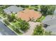 Aerial view of house with brick driveway, mature landscaping, and pond at 27427 Mistflower Dr, Wesley Chapel, FL 33544