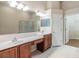 Bright bathroom with double sinks, vanity, large mirror, and access to a walk-in closet at 27427 Mistflower Dr, Wesley Chapel, FL 33544