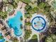Aerial view of community pools, lounge chairs, umbrellas, and surrounding landscaping, offering a resort-style experience at 27427 Mistflower Dr, Wesley Chapel, FL 33544