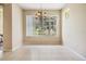 Bright dining room with chandelier, tile floor, and a scenic view of the serene lake at 27427 Mistflower Dr, Wesley Chapel, FL 33544