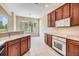 Modern kitchen with wood cabinets, white appliances, and a picturesque view of the lake at 27427 Mistflower Dr, Wesley Chapel, FL 33544