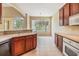 Modern kitchen with wood cabinets, white appliances, tile flooring, and view of the lake at 27427 Mistflower Dr, Wesley Chapel, FL 33544