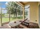 Relaxing screened lanai with brick flooring, outdoor seating, and peaceful lake views at 27427 Mistflower Dr, Wesley Chapel, FL 33544