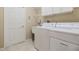 Laundry room equipped with washer, dryer, sink, and shelving for storage at 27427 Mistflower Dr, Wesley Chapel, FL 33544
