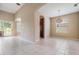 Open-concept living room with tiled floors and natural light; kitchen in background at 27427 Mistflower Dr, Wesley Chapel, FL 33544
