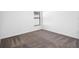 A simple bedroom showcasing neutral carpeting, a window with blinds, and white walls at 29563 Fedora Cir, Brooksville, FL 34602