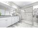 Bright bathroom with double sinks, granite countertop, a glass shower enclosure and neutral colored walls at 30762 Parrot Reef Ct, Wesley Chapel, FL 33545