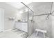 Beautifully tiled bathroom with double sinks, granite countertop, a glass shower enclosure and neutral colored walls at 30762 Parrot Reef Ct, Wesley Chapel, FL 33545