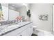 Bright bathroom with double sinks, granite countertop and a shower and tub combo, adorned with plants and tropical towels at 30762 Parrot Reef Ct, Wesley Chapel, FL 33545