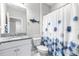 Charming bathroom featuring granite countertops, a shower with a stylish curtain, and marine-themed decorations at 30762 Parrot Reef Ct, Wesley Chapel, FL 33545