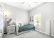 Bright bedroom with a trundle bed, ceiling fan, a large window and neutral colored decor and carpet at 30762 Parrot Reef Ct, Wesley Chapel, FL 33545
