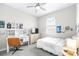 Bright bedroom featuring a desk, TV, closet and ceiling fan, decorated with posters and string lights at 30762 Parrot Reef Ct, Wesley Chapel, FL 33545