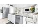 The kitchen features white cabinets, granite counters, stainless appliances and an open view to the living room at 30762 Parrot Reef Ct, Wesley Chapel, FL 33545