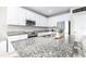 Kitchen with granite counters, stainless appliances, and white cabinets, providing ample space for cooking at 30762 Parrot Reef Ct, Wesley Chapel, FL 33545