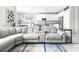 Open-concept living room with a large sectional sofa flows seamlessly into the kitchen and dining areas at 30762 Parrot Reef Ct, Wesley Chapel, FL 33545