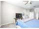 Bright bedroom with a ceiling fan, TV sitting atop a sliding door cabinet and calming blue decor throughout the room at 30762 Parrot Reef Ct, Wesley Chapel, FL 33545