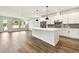 Bright, open kitchen featuring white cabinets, a spacious island, and stainless steel appliances, seamlessly flowing into the living area at 3110 19Th N St, St Petersburg, FL 33713