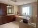 Bathroom featuring double sinks, a large soaking tub, and tiled finishes at 3235 Walnut Ne St, St Petersburg, FL 33704