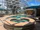 Covered pool and hot tub area with patio seating and blue umbrellas at 3235 Walnut Ne St, St Petersburg, FL 33704
