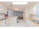 Open kitchen featuring white cabinets, appliances, and bar seating, with a view into the living room at 3301 Alt 19 # 819, Palm Harbor, FL 34683