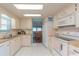 Well-lit kitchen with wooden countertops, white cabinets, and a view of the adjacent dining area at 3301 Alt 19 # 819, Palm Harbor, FL 34683