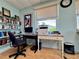 Office space with desk, chair, computer, printer, shelves with books, and a window that looks out over the community at 3301 Alt 19 # 819, Palm Harbor, FL 34683
