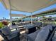 Outdoor seating area with comfortable sofas and chairs arranged around a fire pit under a shaded patio, community amenities nearby at 3301 Alt 19 # 819, Palm Harbor, FL 34683