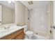 Simple bathroom featuring a wood vanity, commode and a white tiled shower with neutral wall color at 3389 Crystal E Ct # J, Palm Harbor, FL 34685