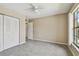 Bright bedroom featuring neutral walls, gray carpet, and a ceiling fan at 3389 Crystal E Ct # J, Palm Harbor, FL 34685